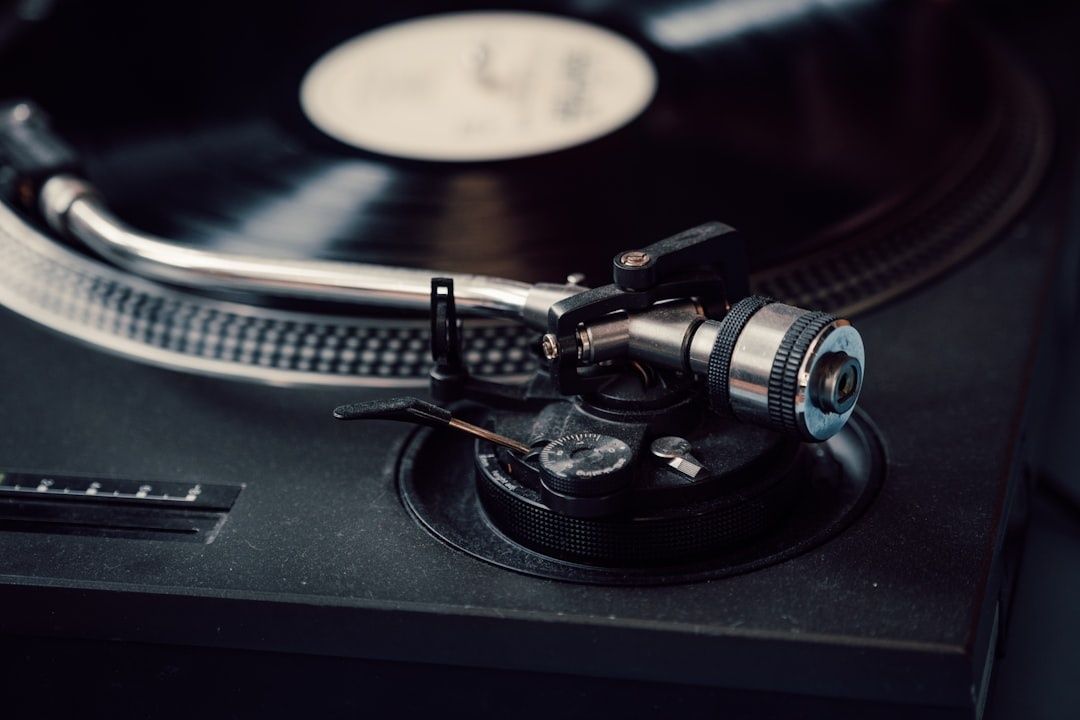 Närbild av en Technics-liknande vinylspelare med skiva och tonarm