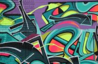 Färgstark graffitimålning med abstrakta former på en tegelvägg