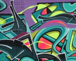Färgstark graffitimålning med abstrakta former på en tegelvägg