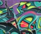 Färgstark graffitimålning med abstrakta former på en tegelvägg