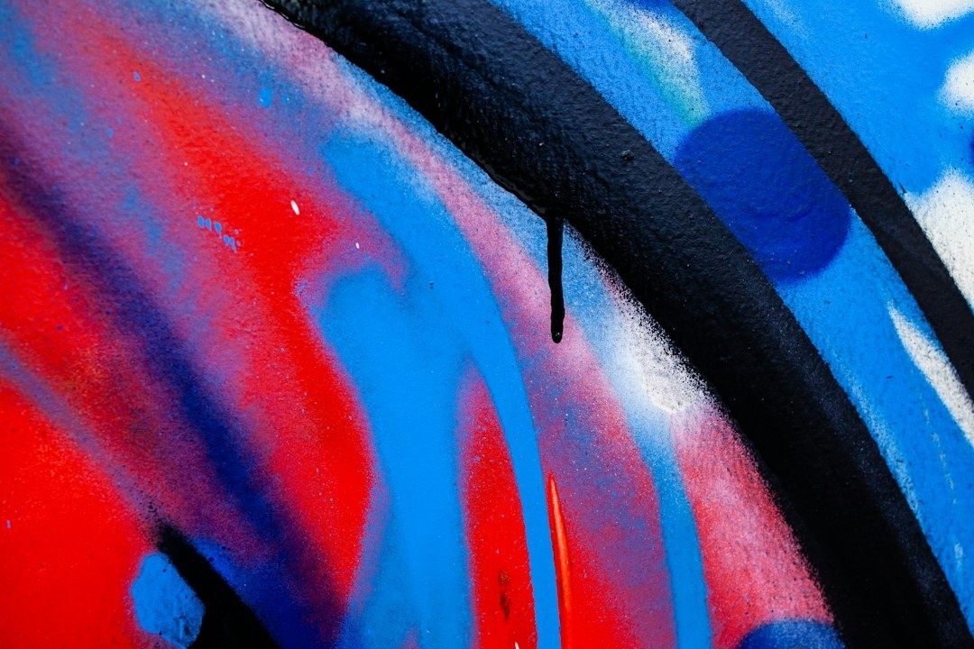 Närbild av färgstark graffiti i rött, blått, rosa och svart
